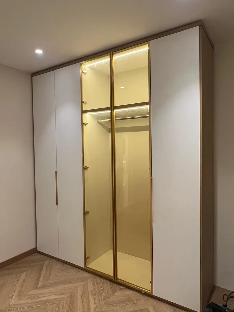 Installed wardrobe with gold-framed glass doors